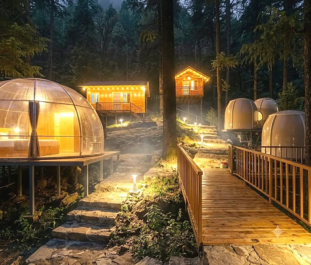 Glass domes and wooden cabins in the forest at night, joined by a boardwalk