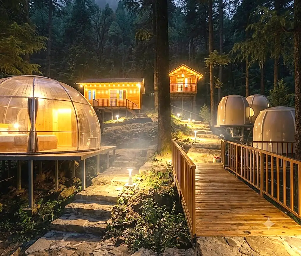 Glass domes and wooden cabins in the forest at night, joined by a boardwalk