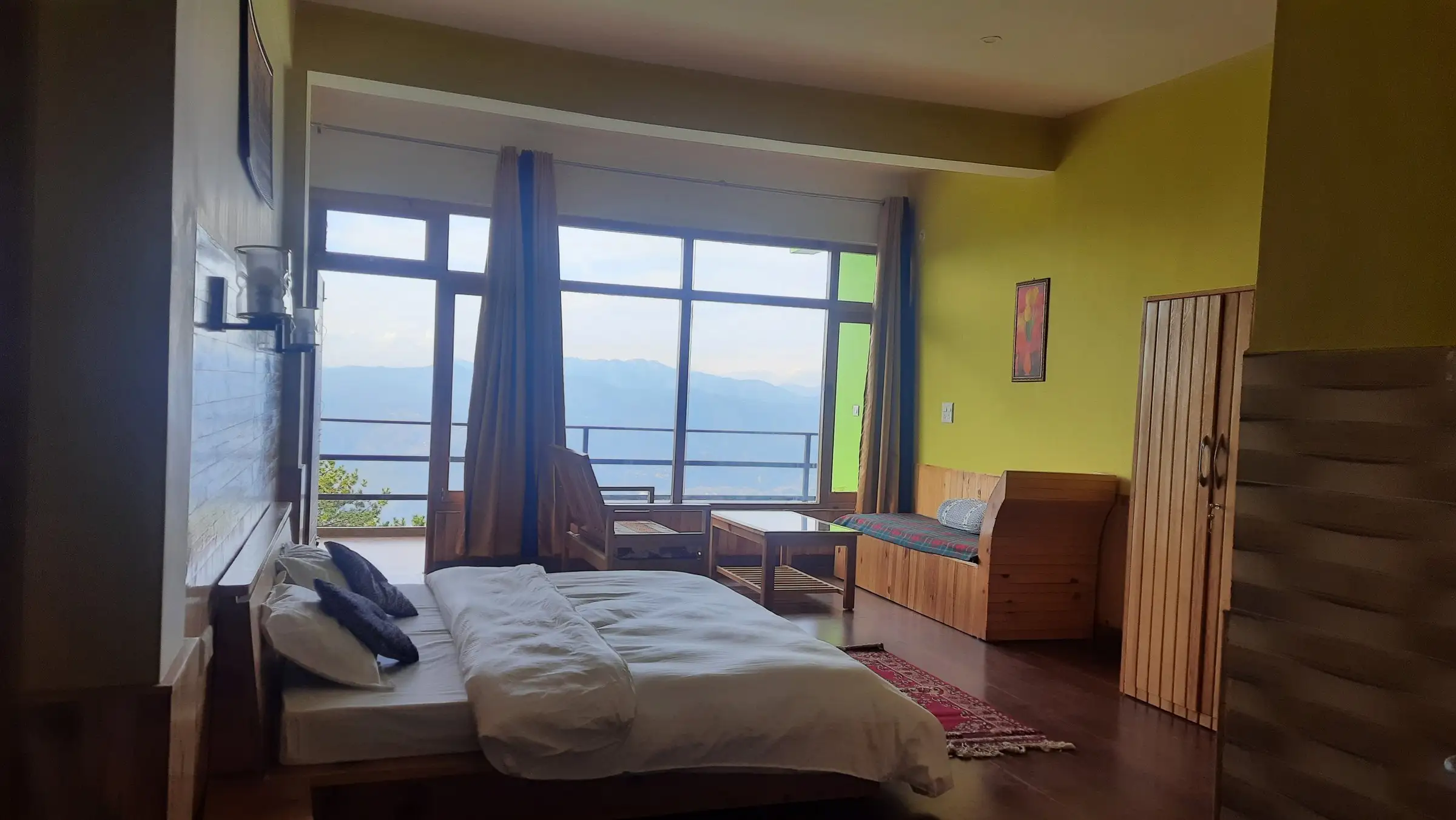 A room with a green wall, a built-in bench and a window wall