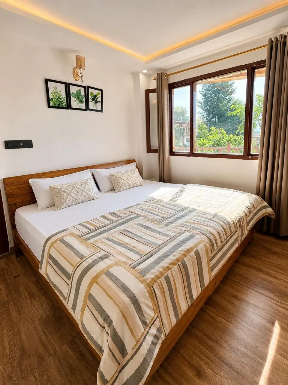 A second bedroom with a striped quilt and a window onto trees