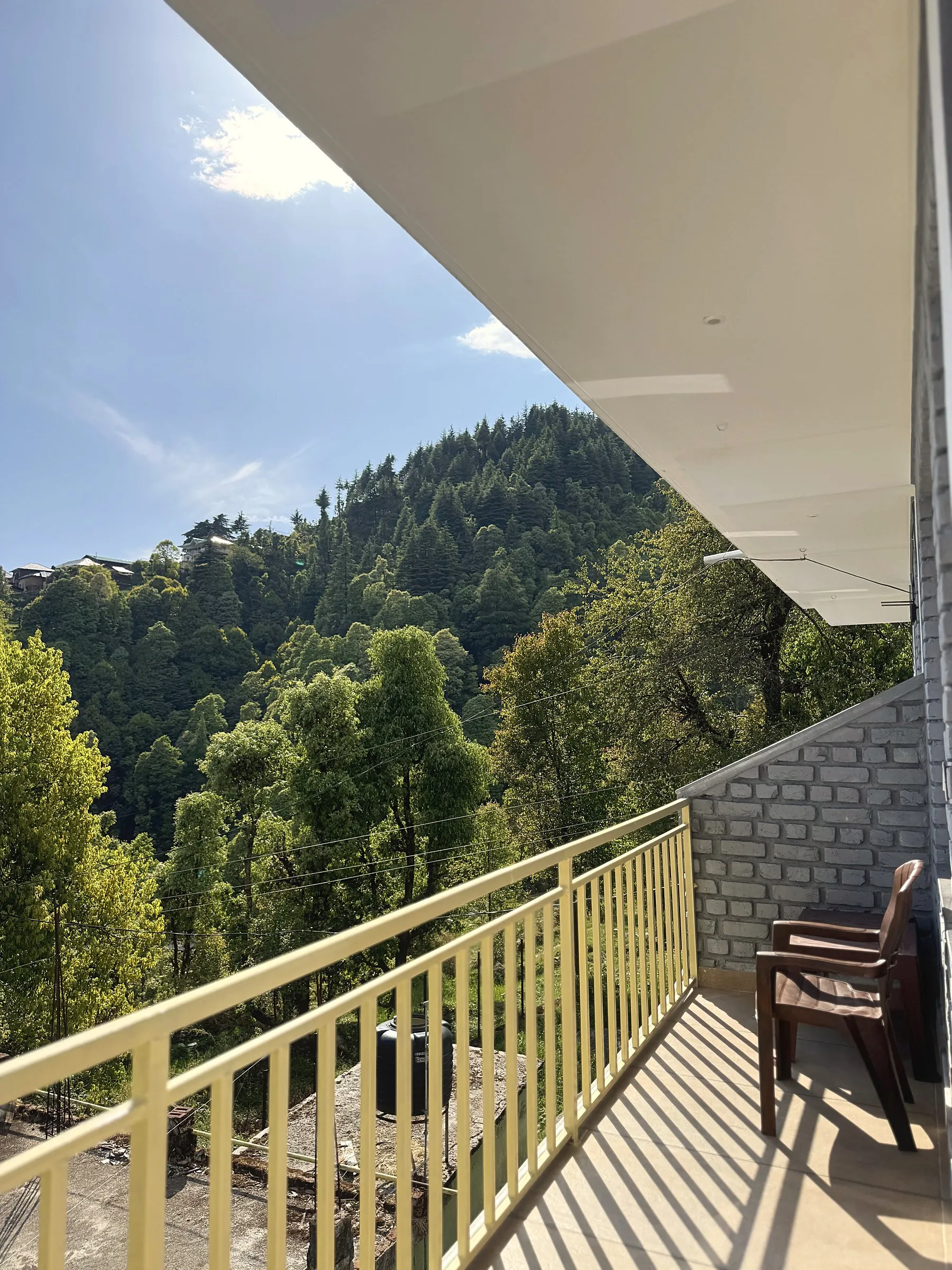 The balcony, with two chairs facing a forested ridge