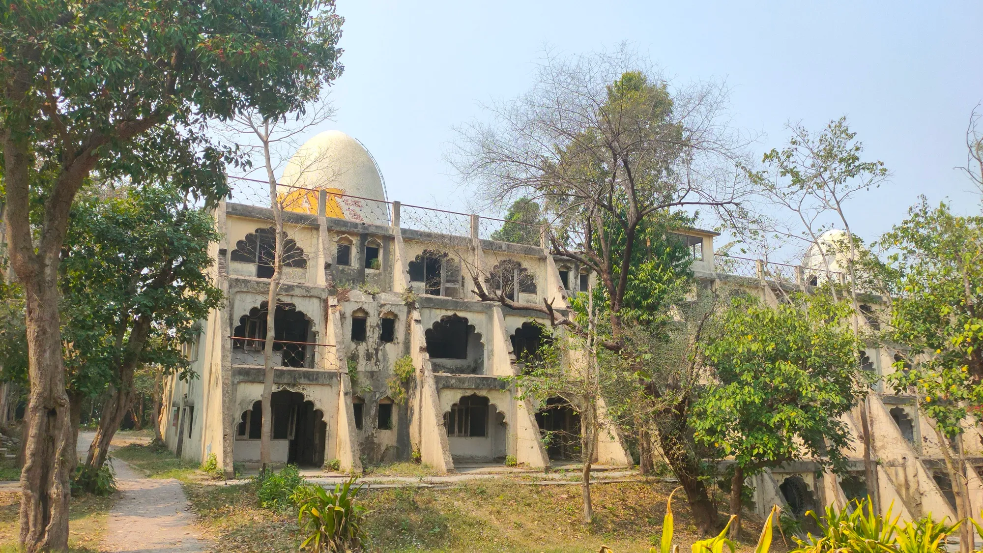 An old stone building among trees at the Beatles Ashram