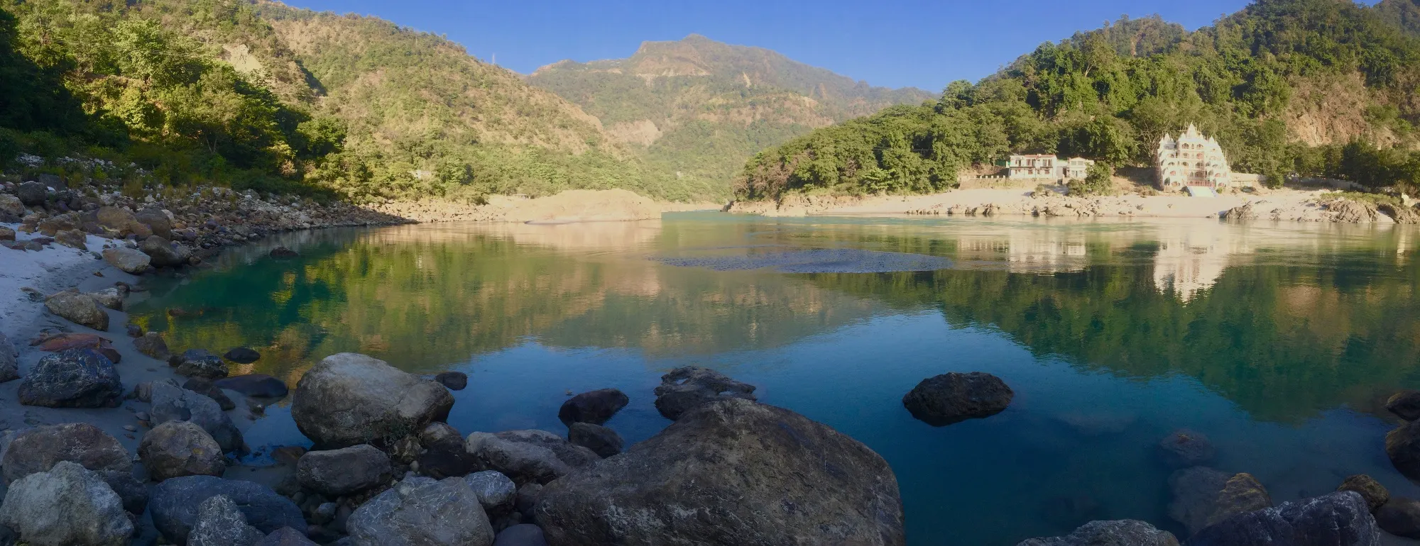 The Ganga running between boulders and forest at Rishikesh