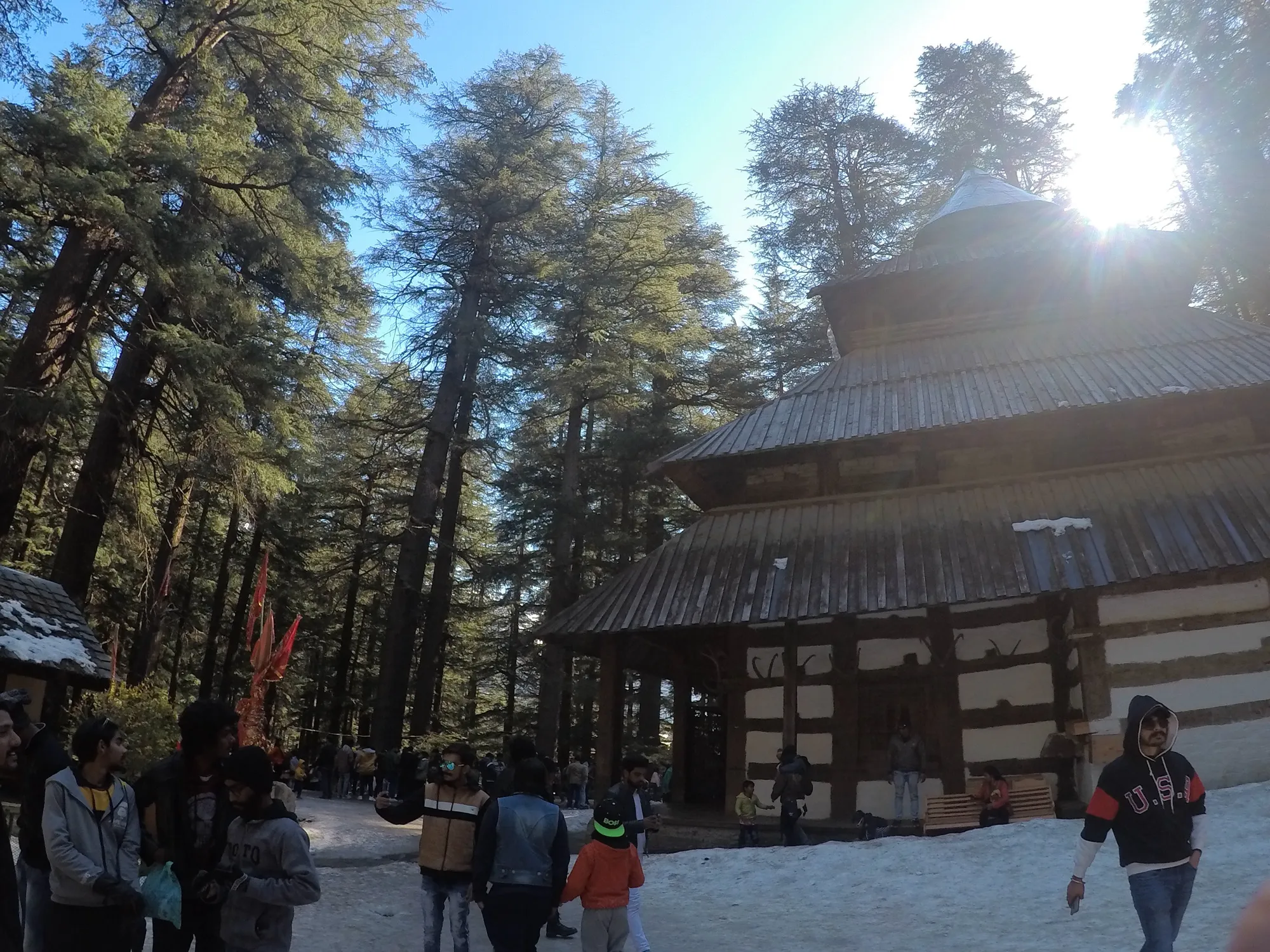 Hadimba Devi temple in snow, with visitors on the path in front