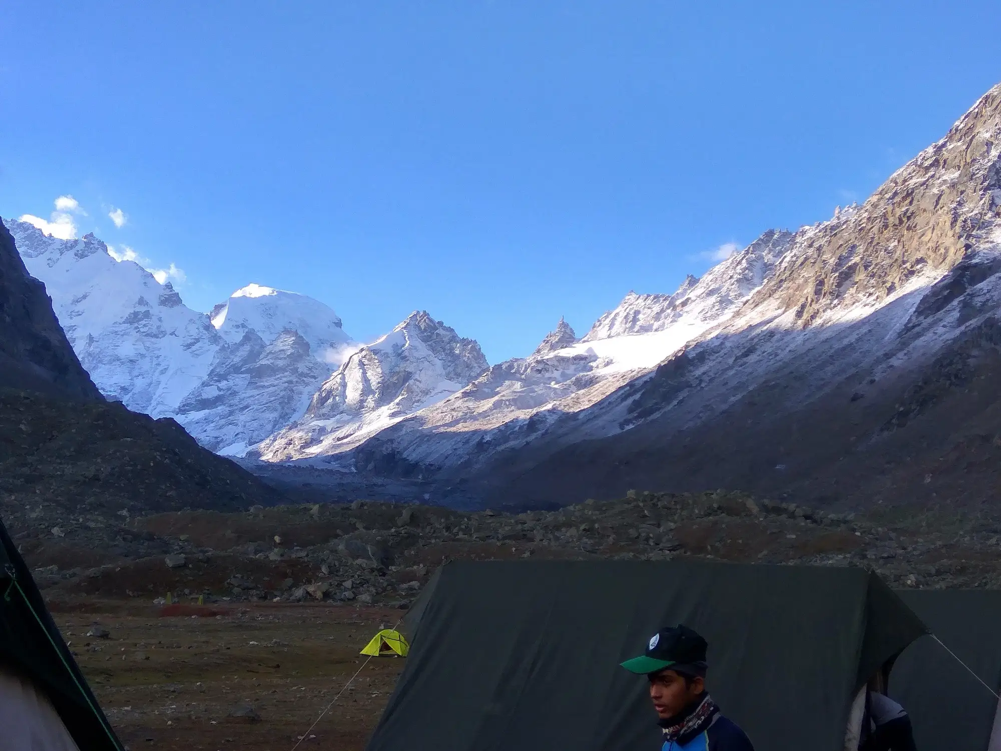 Sharp rock peaks with snow near Hampta Pass under a pale sky