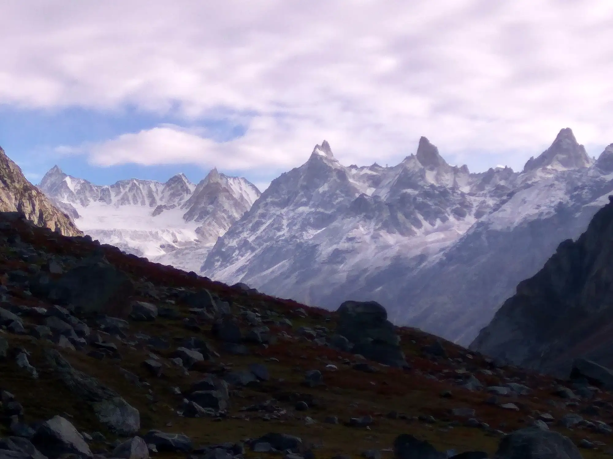 A tent below the snow peaks near Hampta Pass in fading light