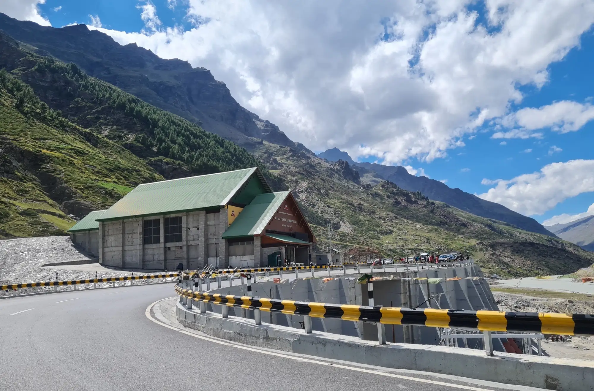 The portal building of the Atal Tunnel with a mountain road curving up to it