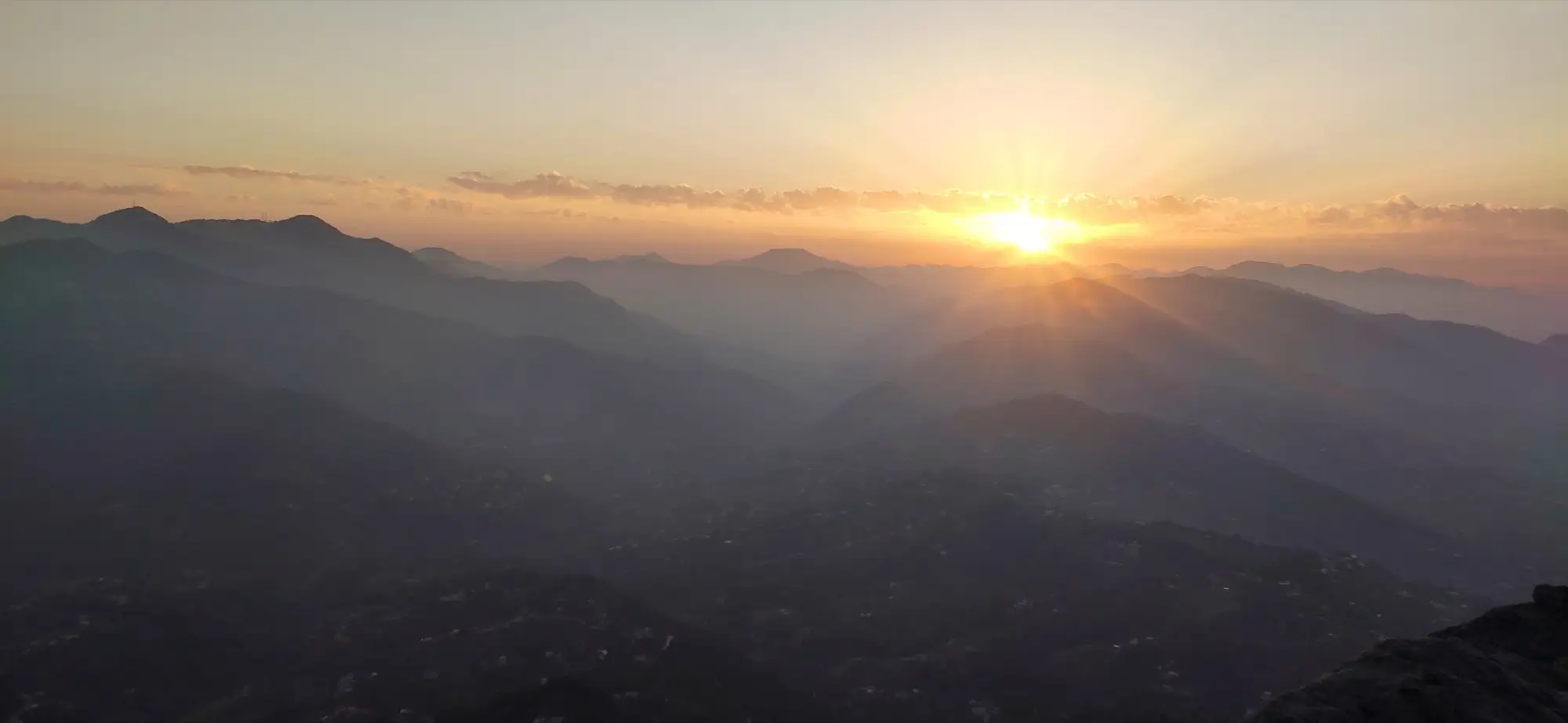 Sun setting over layered ridges seen from Mukteshwar