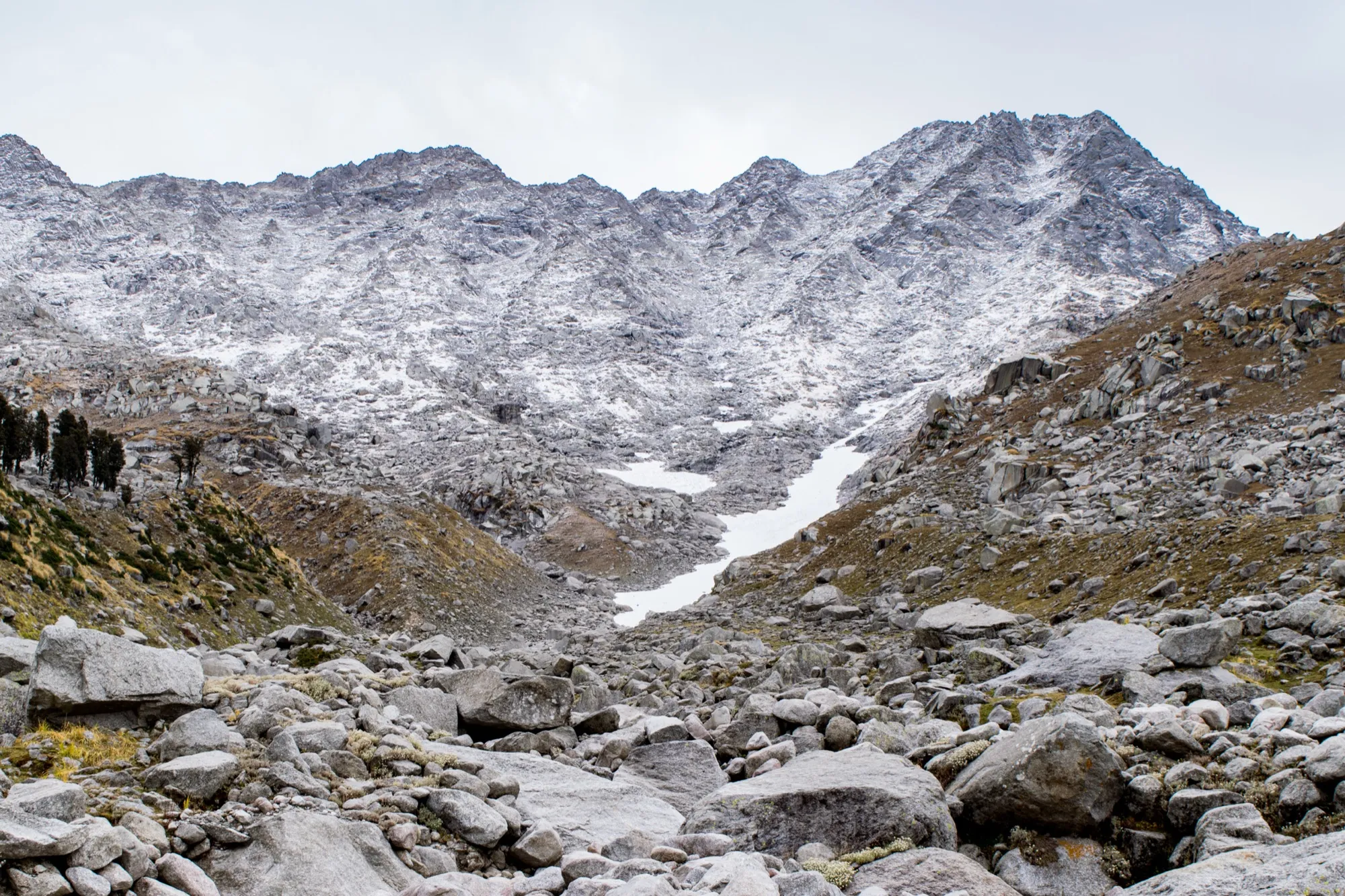 Rock, scree and fresh snow on the slope below Indrahar Pass