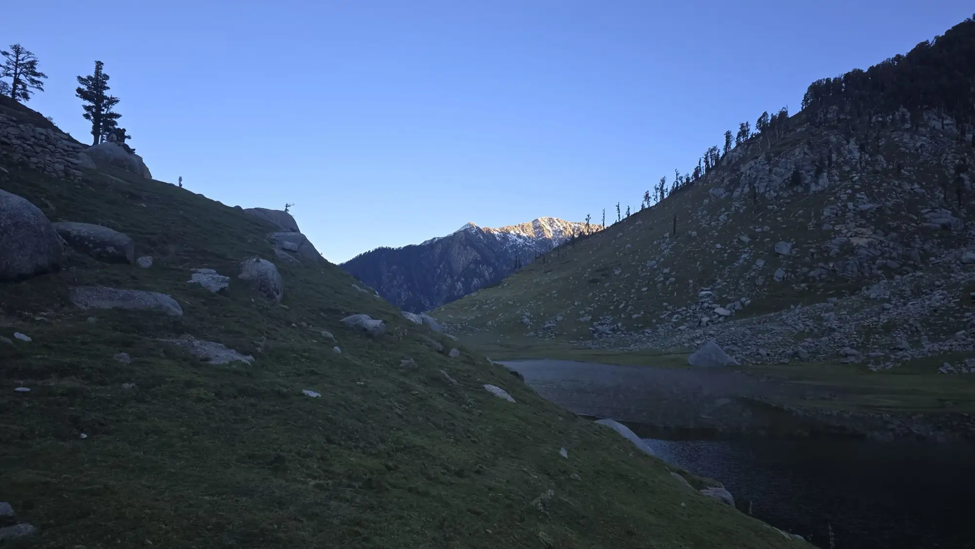 Kareri Lake in shadow between steep slopes
