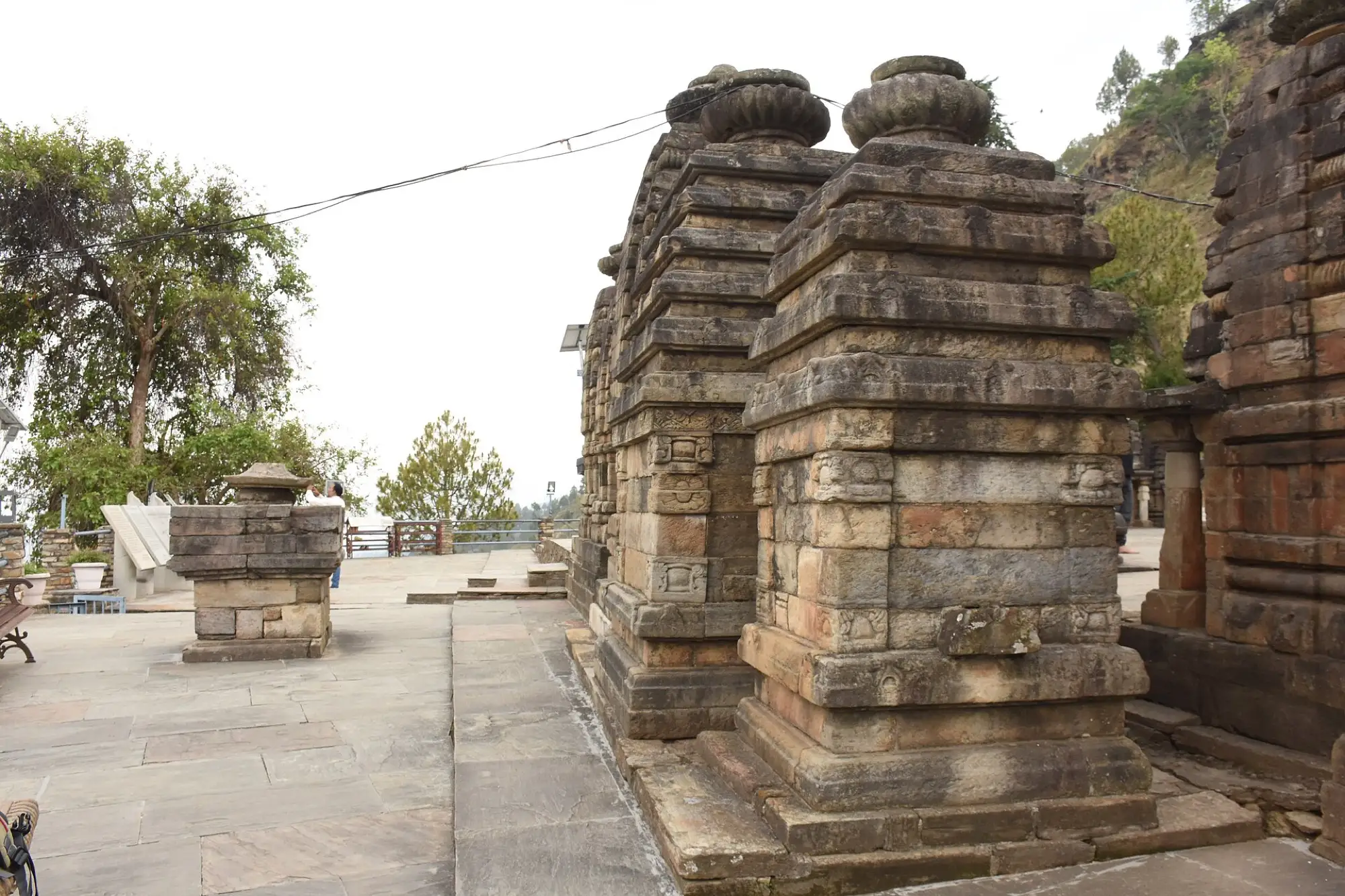 A stone shrine with a stepped spire standing on a paved terrace at Katarmal