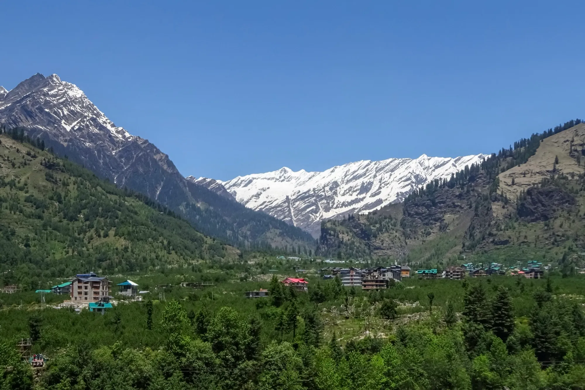 The Kullu valley north of Manali town, with forested slopes and snow on the ridge