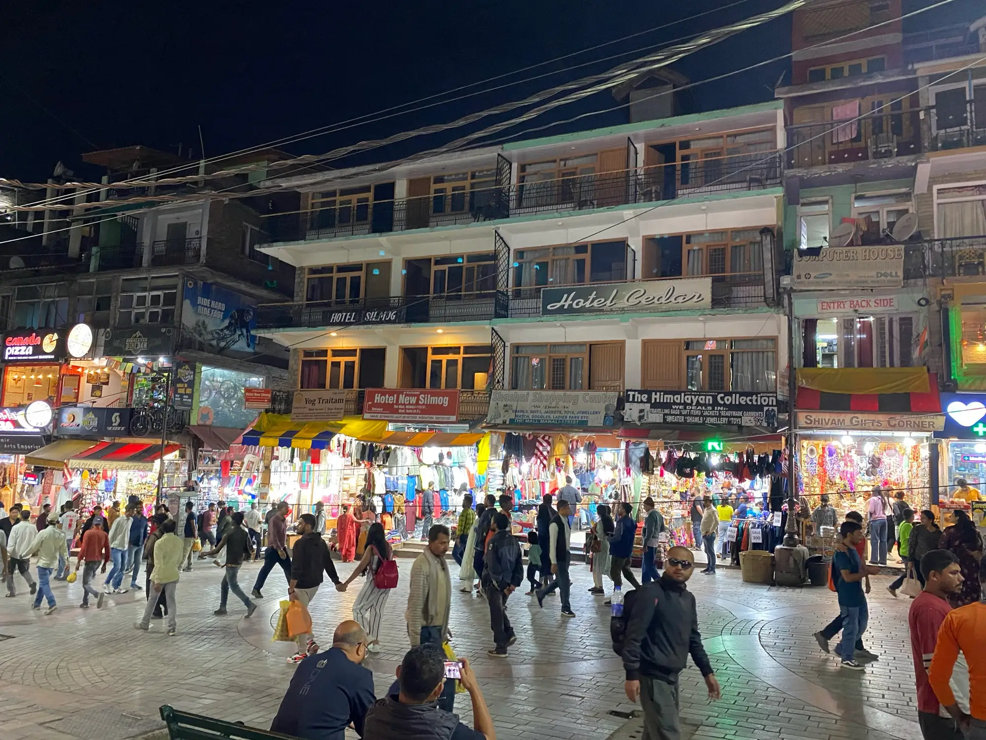 Manali's market lit up at night and full of people