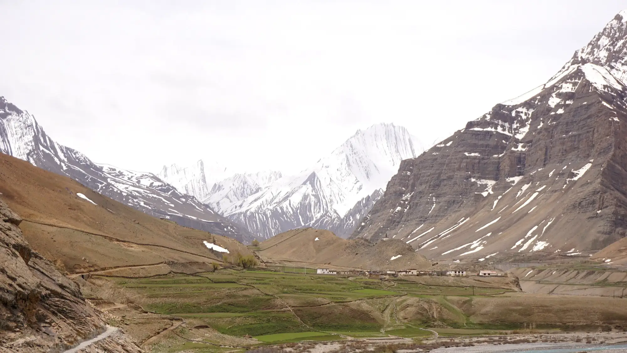 The village of Mud with green fields below snow peaks in the Pin valley