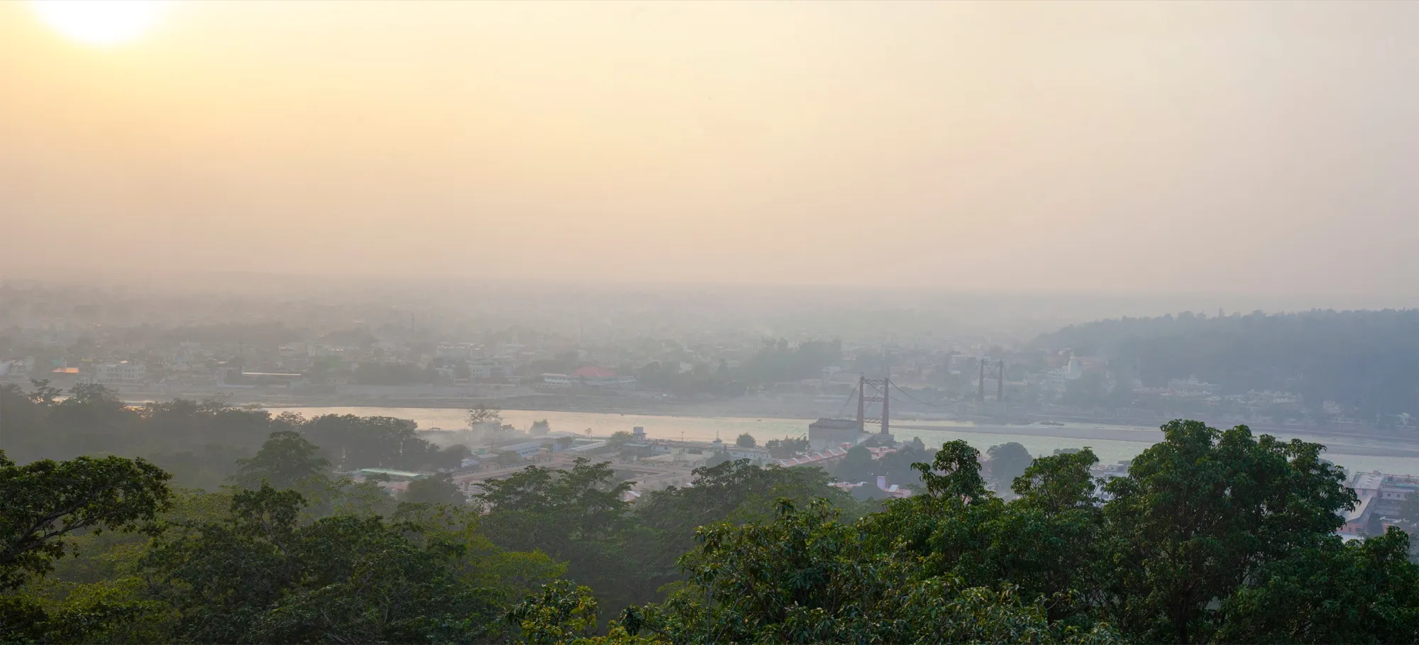 Rishikesh at sunset with the Ram Jhula bridge across the Ganga