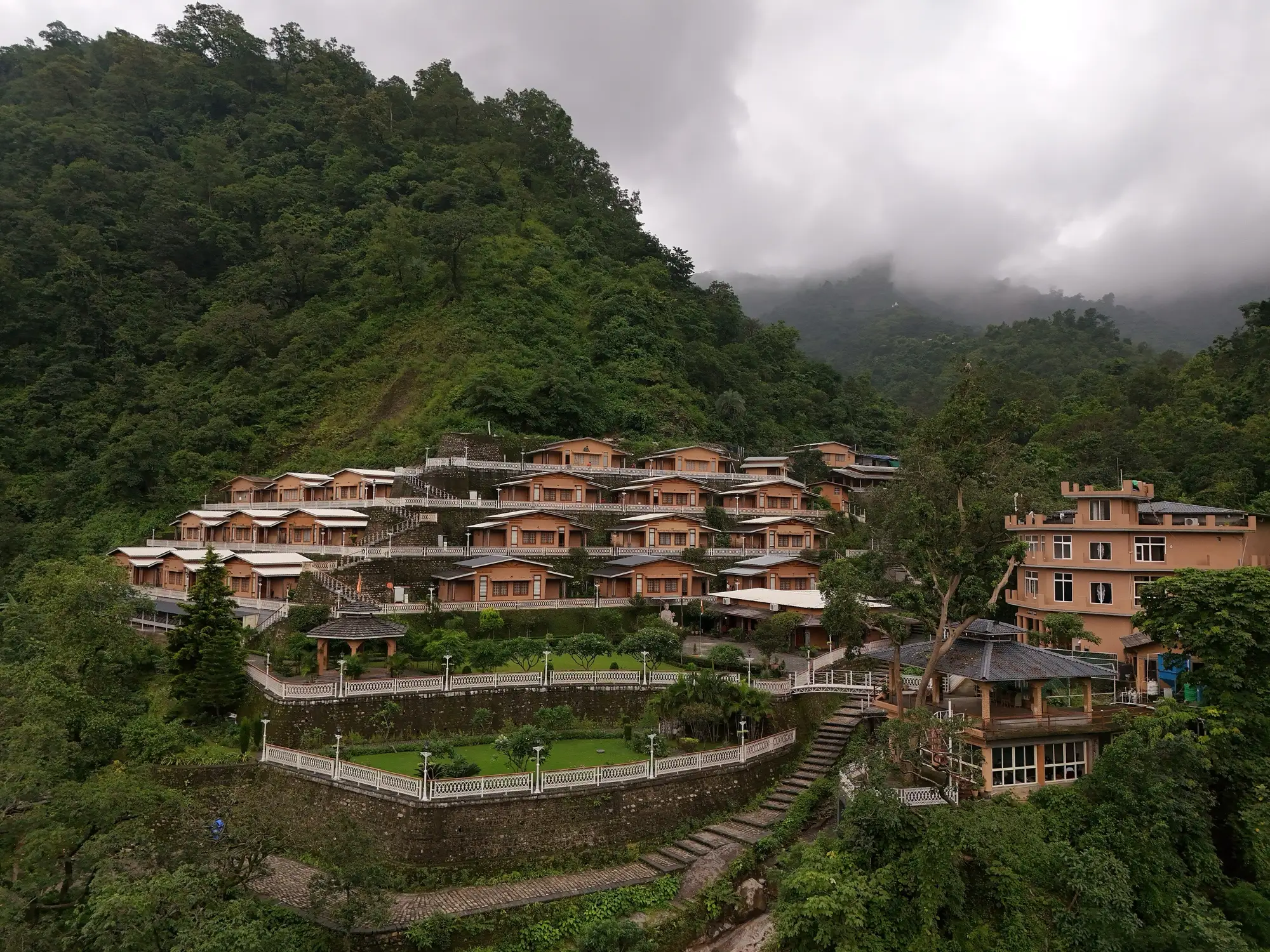 A yoga ashram built in terraces on a forested hillside at Rishikesh