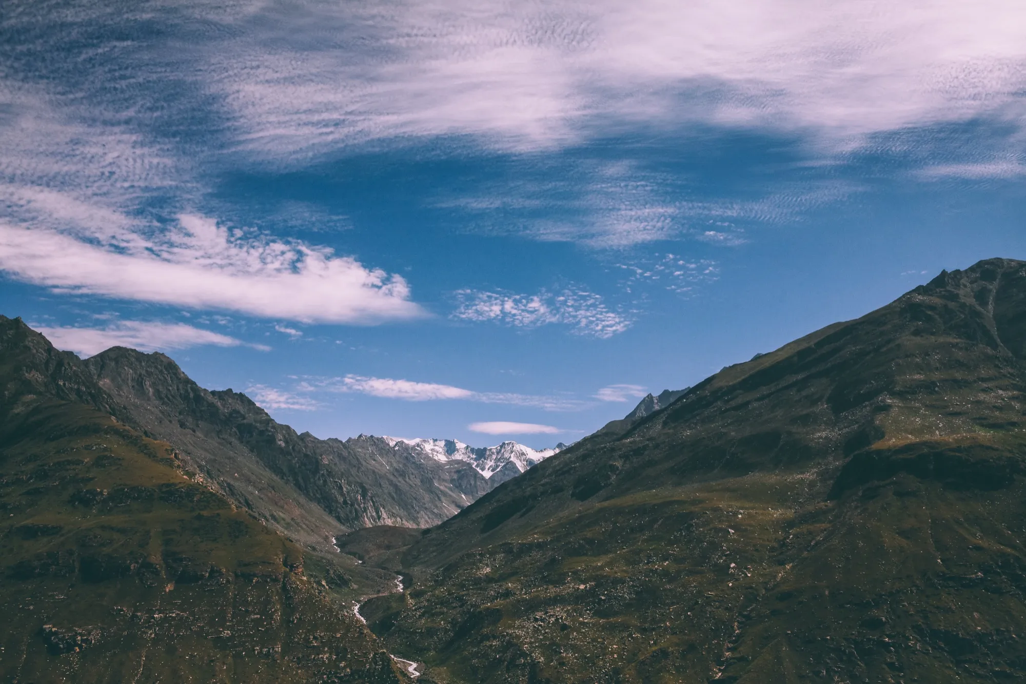 Green slopes and streaked clouds at Rohtang Pass