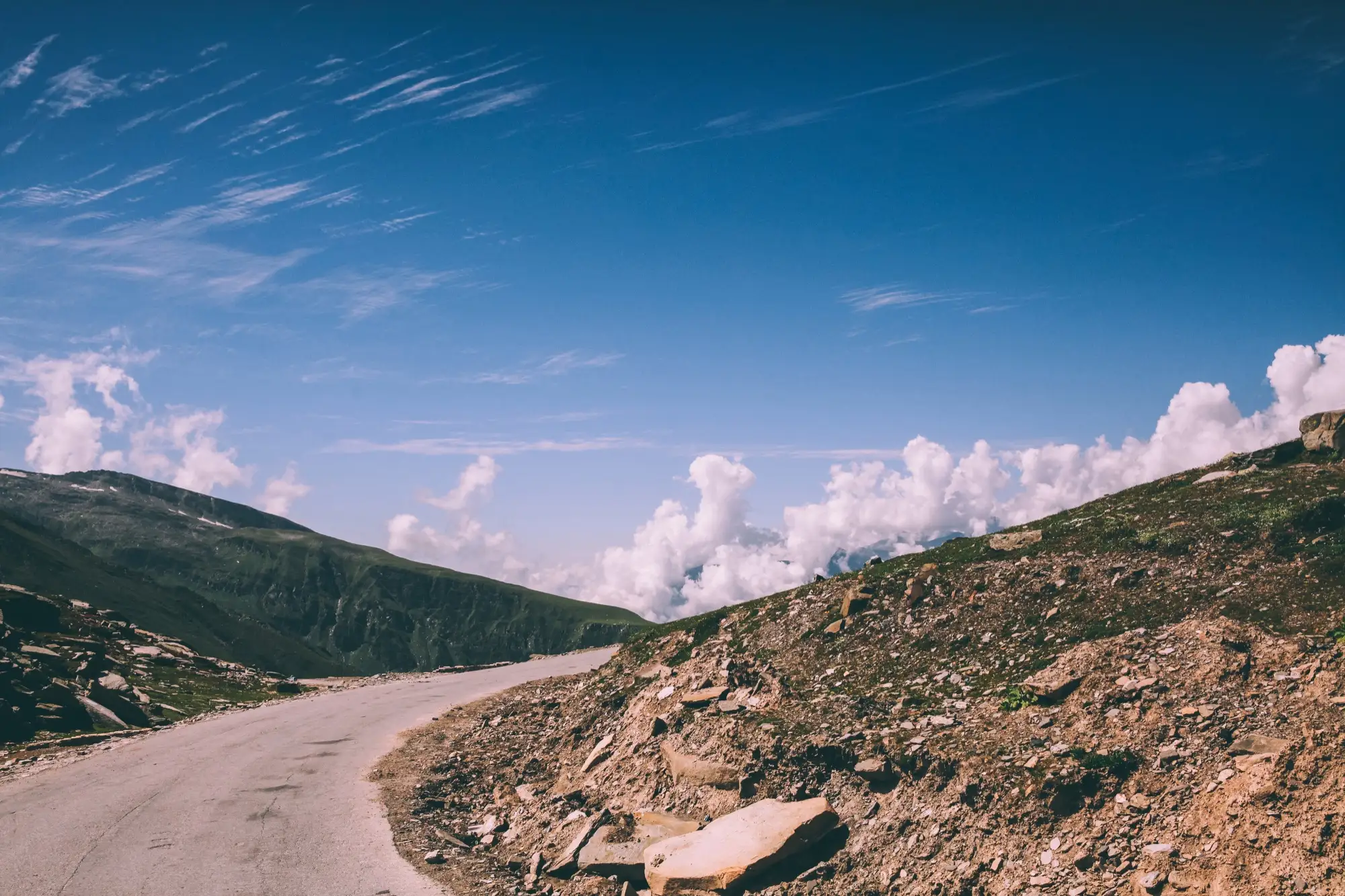 A mountain road curving through rocky slopes at Rohtang Pass