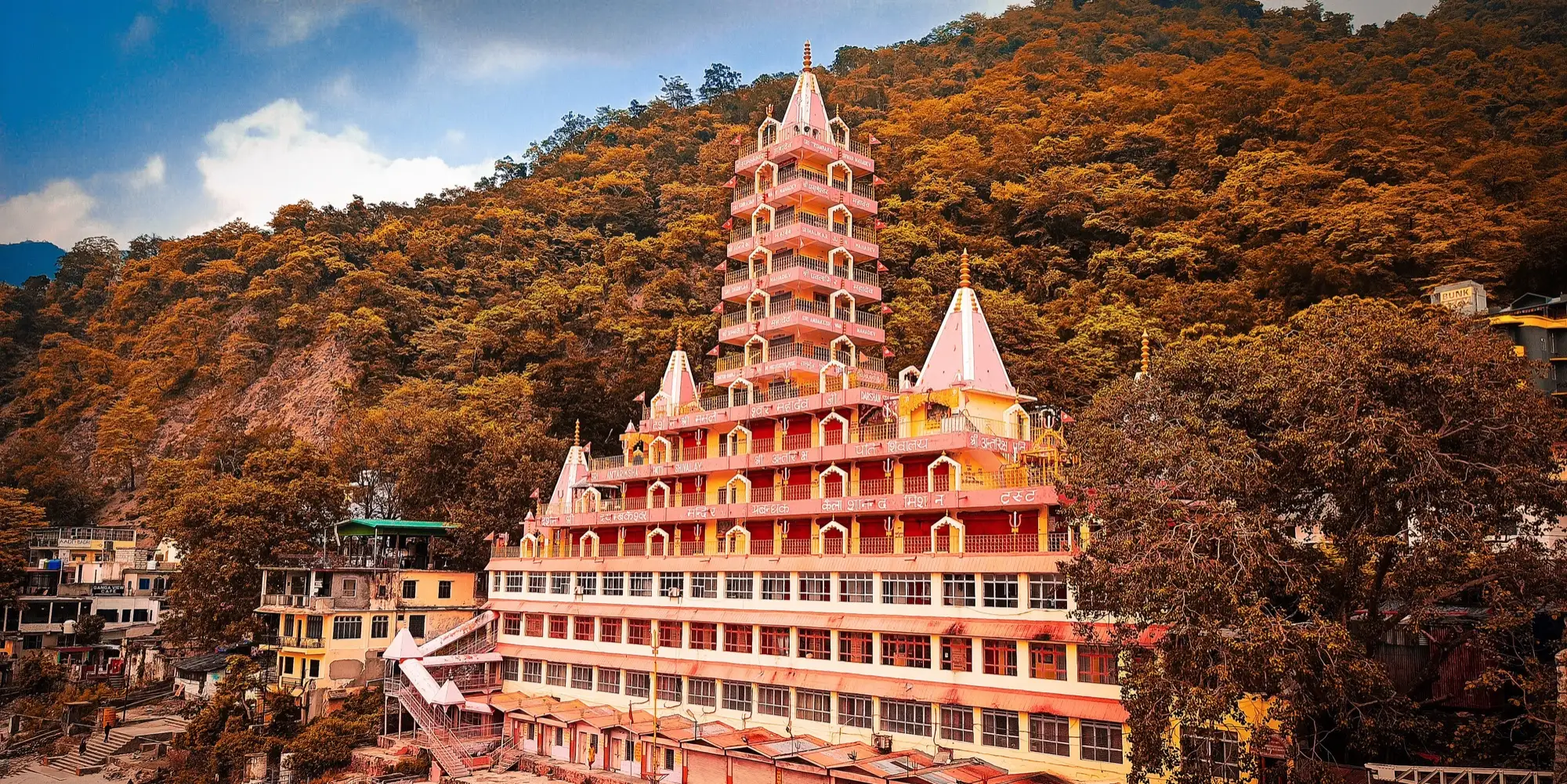 The orange, many-tiered Trayambakeshwar temple rising above the river bank