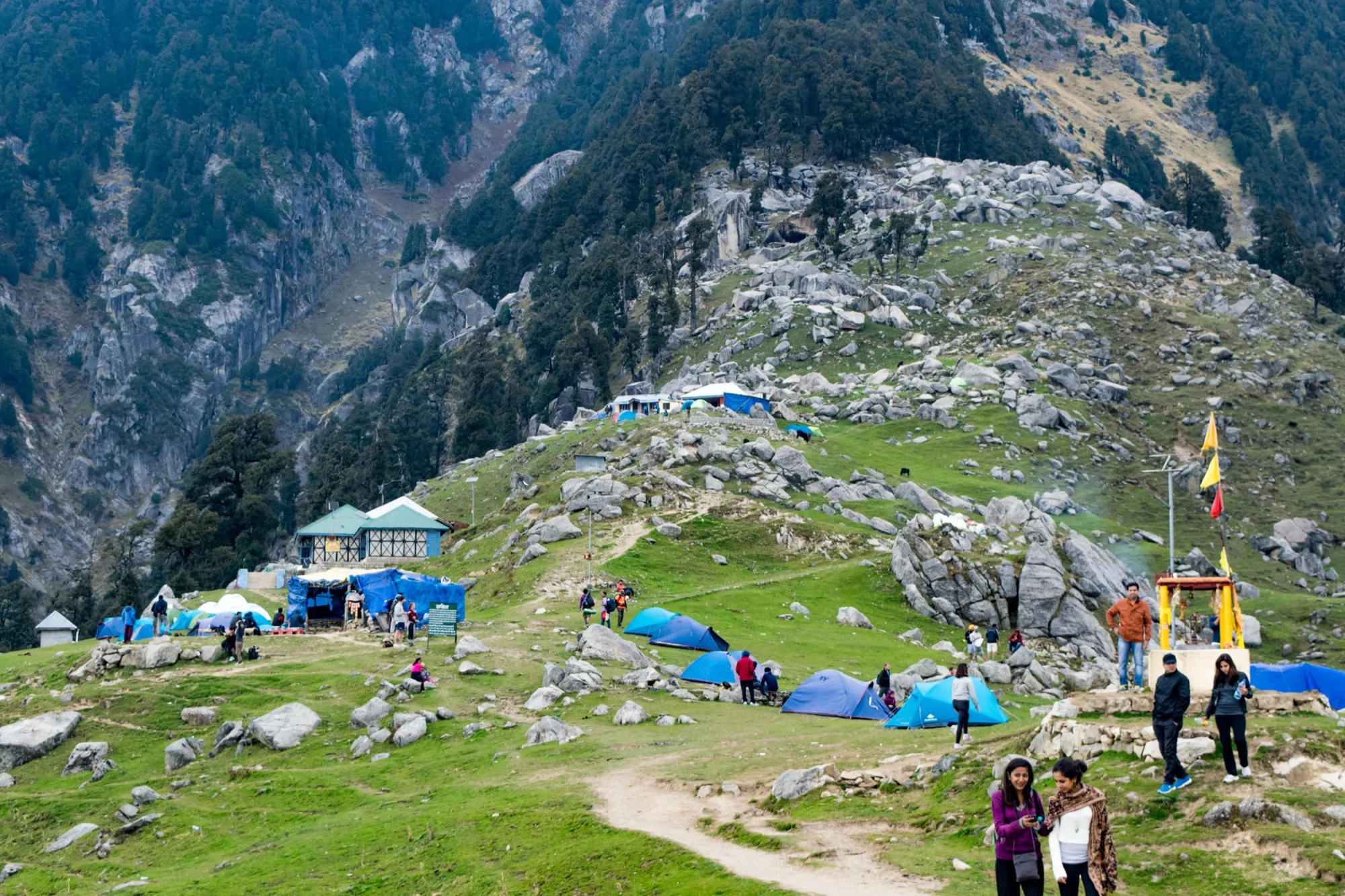 Tents, tea stalls and walkers on the grassy ridge at Triund
