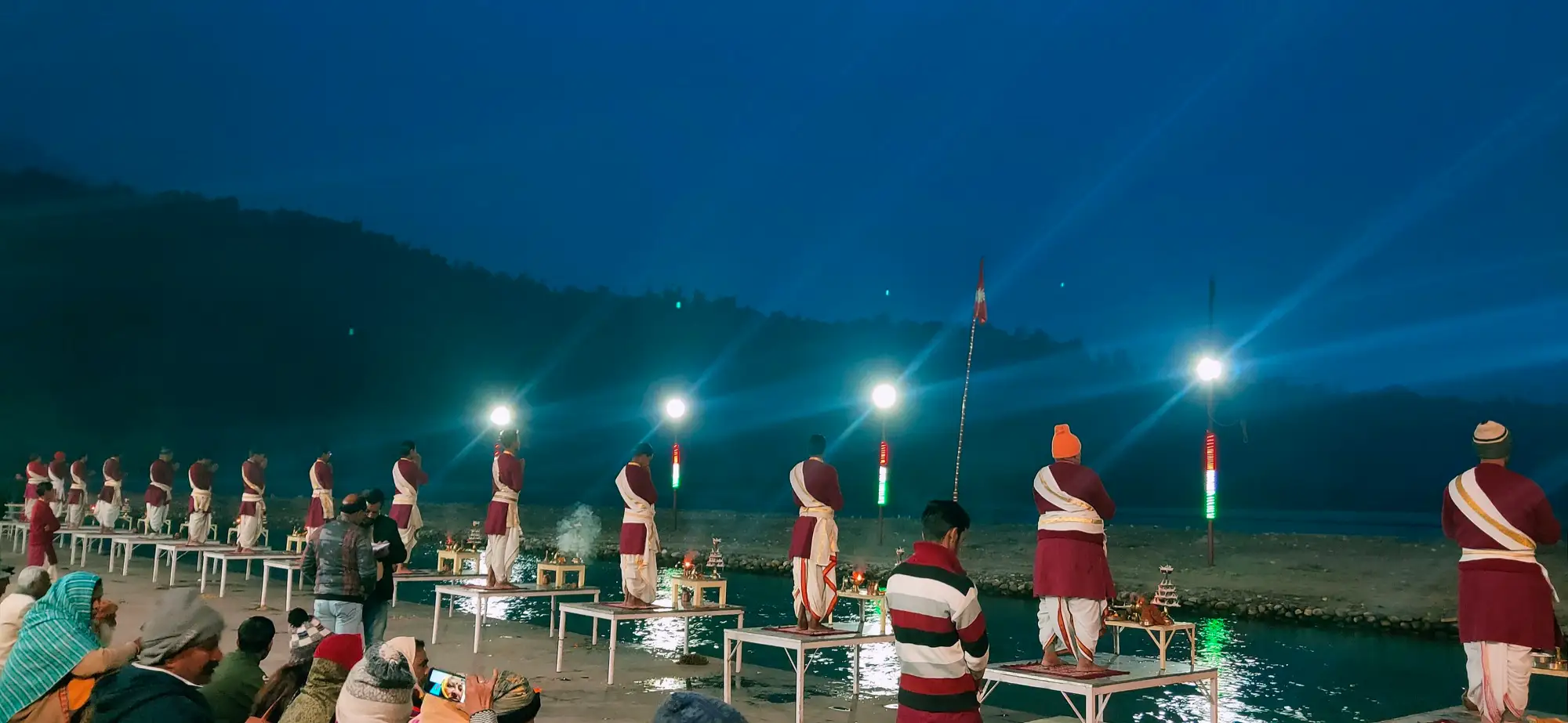 Priests holding lamps in a row during the Ganga aarti at Triveni Ghat